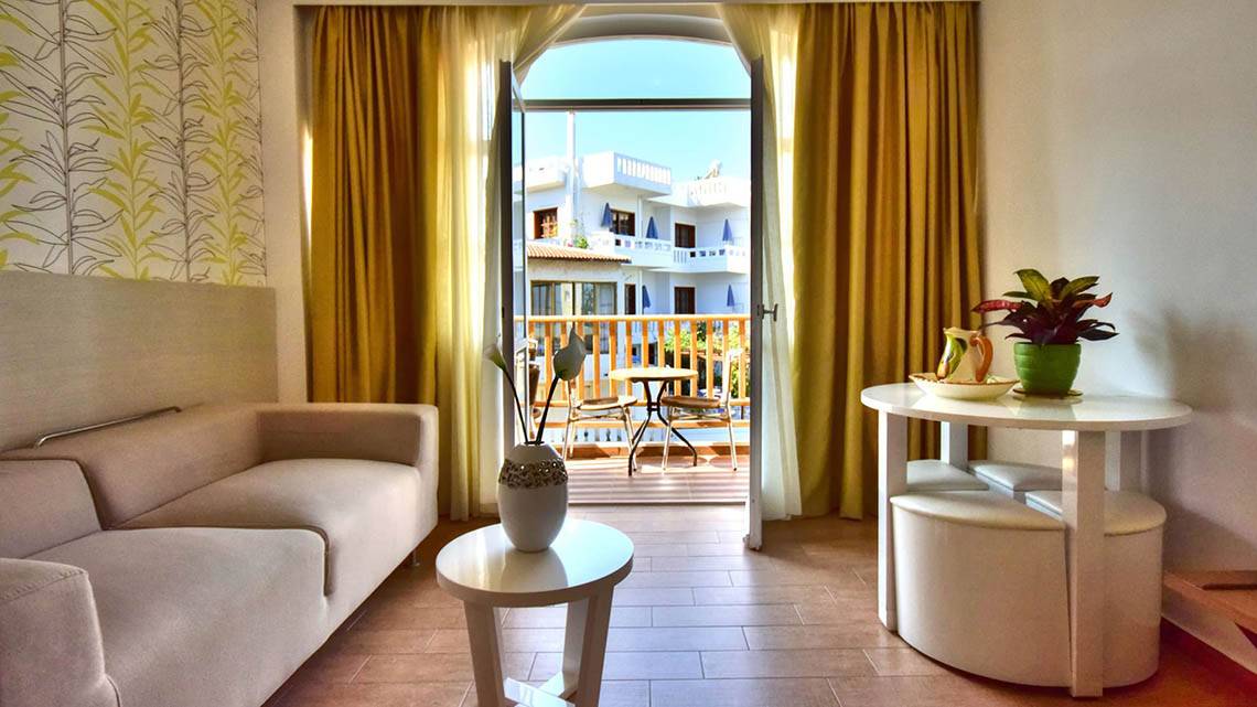 Wohnzimmer mit Sofa und Balkon im Kalyves Beach Hotel.