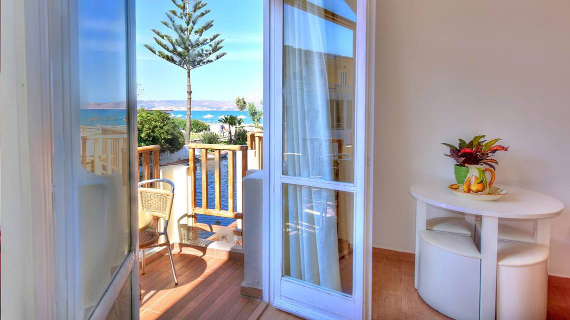 Ein Balkon des Kalyves Beach Hotels mit Blick auf den Strand und das Meer.