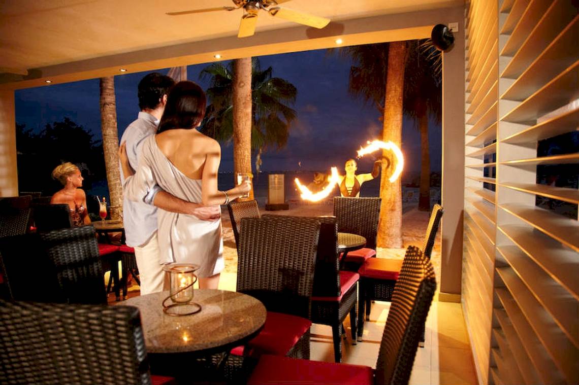 Paar auf der Terrasse des Riu Palace Peninsula Hotels, das eine Feuershow beobachtet
