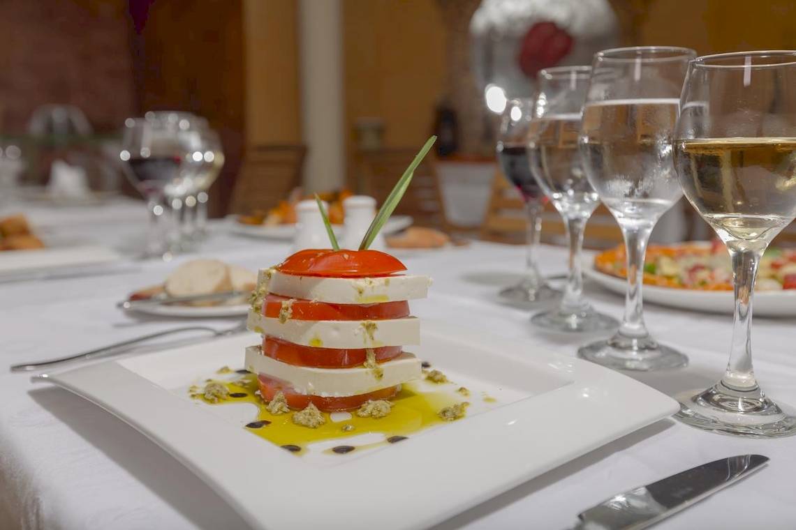 Gericht auf einem Teller im Hotel Melia Las Antillas mit Tomaten, Käse und Öl.