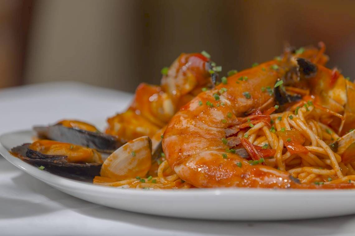 Nahaufnahme eines Tellers mit einem Gericht aus Spaghetti, Garnelen und Muscheln, serviert im Melia Las Antillas Hotel.