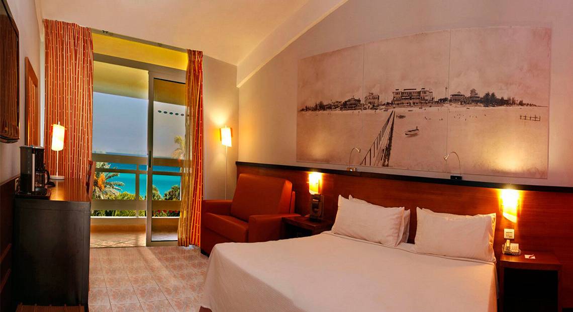 Hotelzimmer im Occidental Arenas Blancas mit Blick auf das Meer und einem großen Wandbild.
