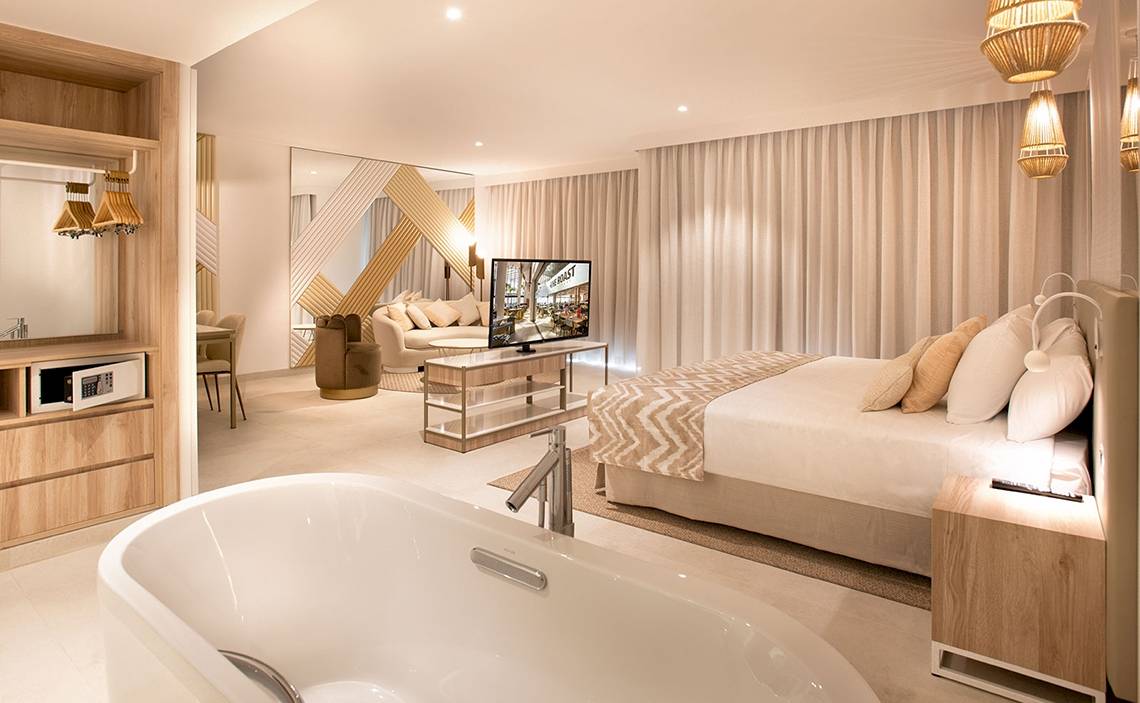 Schlafzimmer im Guayarmina Princess Hotel mit Bett, Fernseher, Badewanne und Möbeln.