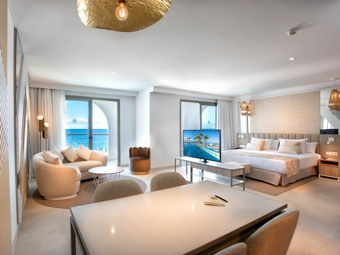 Innenansicht der Guayarmina Princess Suite mit Meerblick, moderner Einrichtung und einem großen Bett.