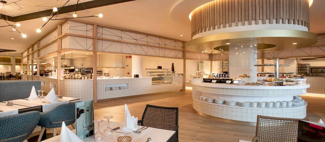 Innenansicht des Restaurants im Guayarmina Princess Hotel mit Esstischen, Stühlen und einer großen Speisentheke.