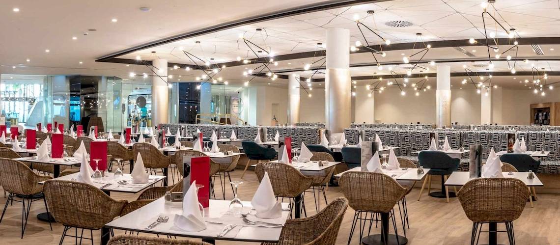 Restaurant im Guayarmina Princess Hotel mit gedeckten Tischen und Stühlen.