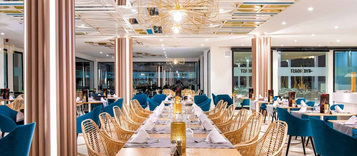 Innenansicht des Restaurants des Guayarmina Princess Hotels mit blauen Stühlen und Tischen.