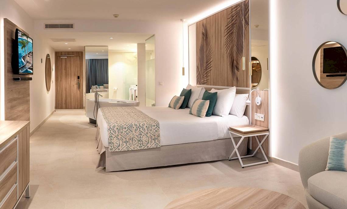 Innenansicht eines Hotelzimmers im Guayarmina Princess mit Bett, Badezimmer und Fernseher.