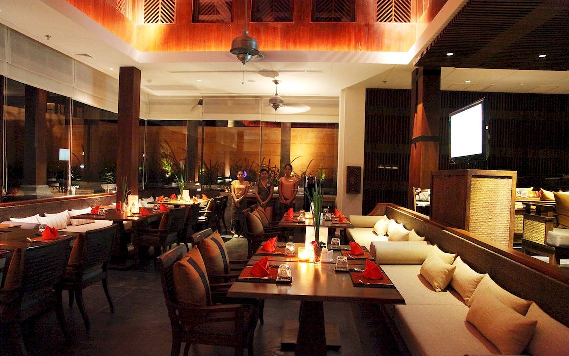 Innenbereich des Restaurants im Mai Samui Beach Resort & Spa mit gedeckten Tischen und stehenden Gästen.
