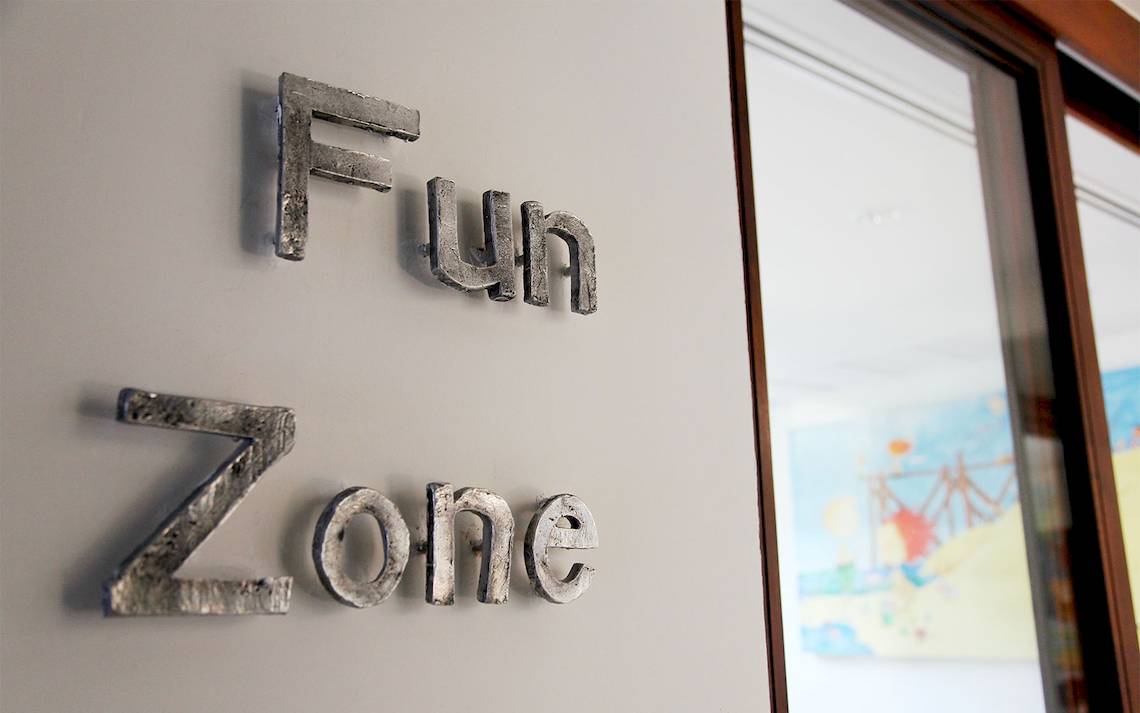 Das Schild mit dem Wort 'Fun Zone' ist an einer Wand befestigt.