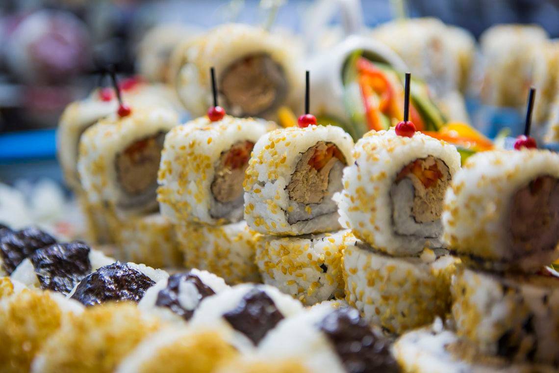 Nahaufnahme von verschiedenen Sushi-Rollen, die mit Zahnstochern und Toppings garniert sind, serviert im Seashell Resort & Spa.