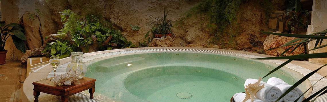 Jacuzzi im Freien mit Pflanzen im Hintergrund im Coral Beach Hotel & Resorts