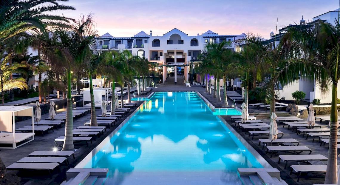 Außenpool des Barceló Teguise Beach Adults Only Hotels mit Liegestühlen und Palmen
