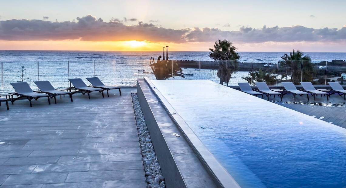 Barceló Teguise Beach Adults Only Pool bei Sonnenuntergang mit Blick auf das Meer.