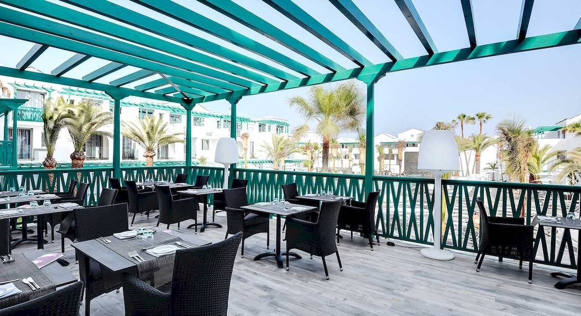 Terrasse des Barceló Teguise Beach Adults Only Hotels mit Tischen und Stühlen