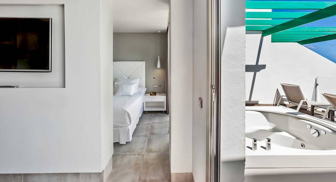 Innenansicht des Barceló Teguise Beach Adults Only Hotels mit einem Bett, Fernseher und einem kleinen Tisch