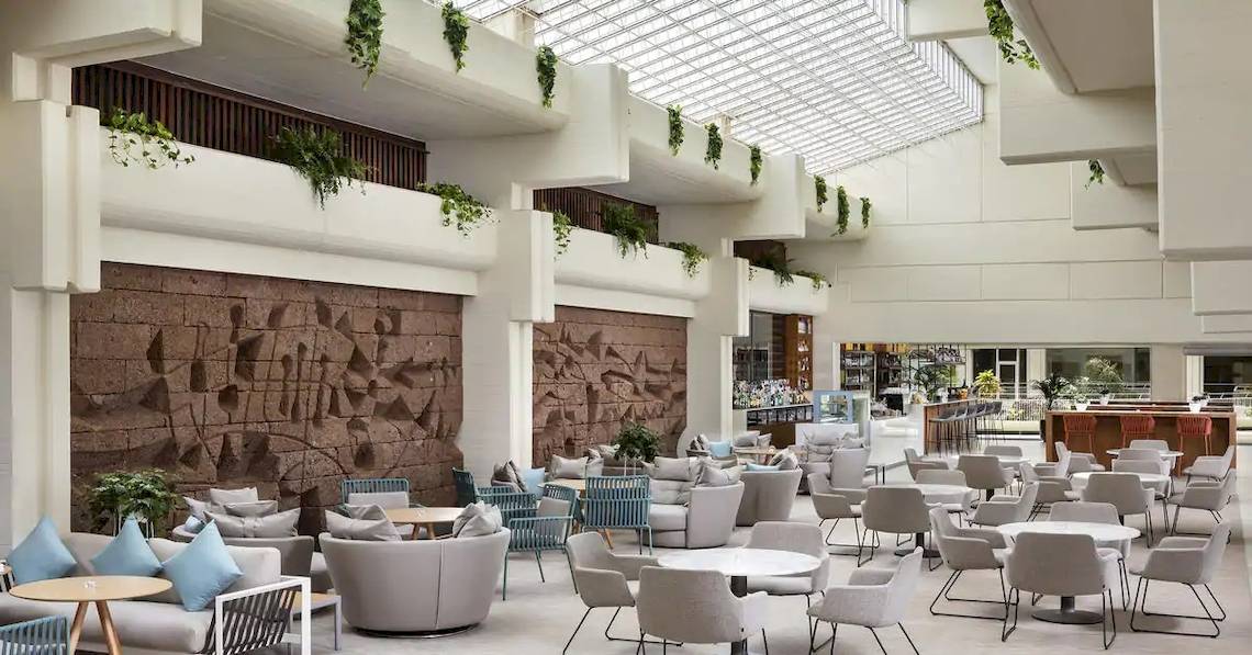 Lobby des Melia Salinas Hotels mit vielen Stühlen, Tischen und Pflanzen.