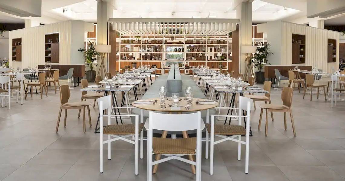 Innenansicht des Restaurants im Melia Salinas Hotel mit leeren Tischen, Stühlen und Regalen.
