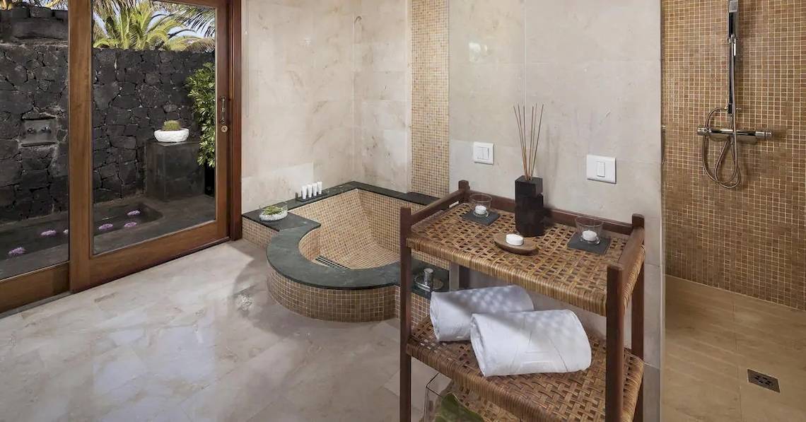 Das Badezimmer im Melia Salinas Hotel mit einer Badewanne, einem Regal und einer Dusche.