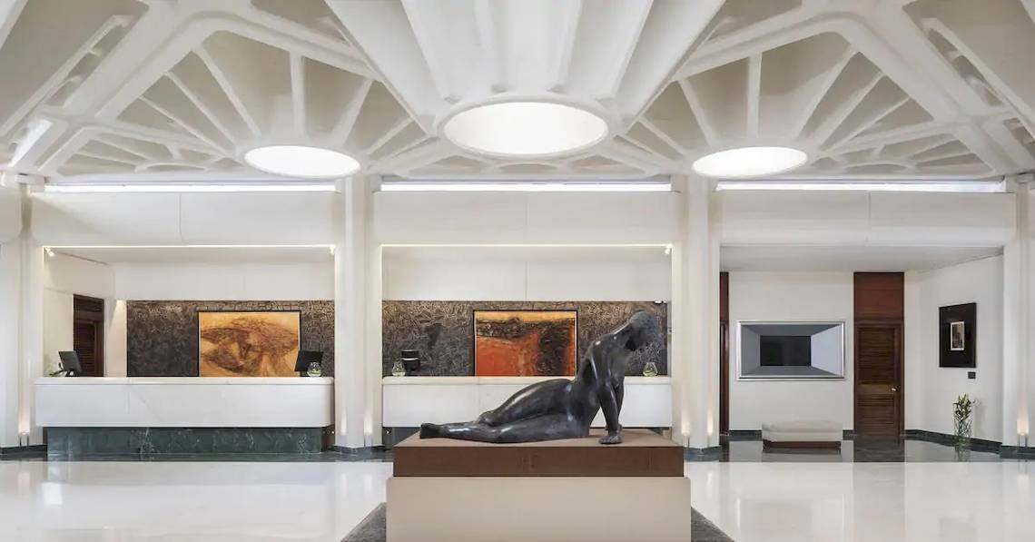 Empfangsbereich des Melia Salinas Hotels mit einer Skulptur im Vordergrund und Gemälden an den Wänden.