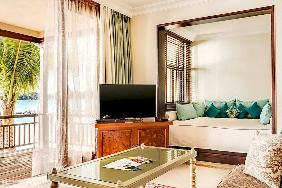 Innenraum des Westin Turtle Bay Resorts & Spa mit Blick auf das Meer und einem Sofa mit Fernseher.