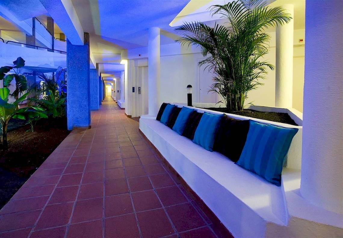 Innenbereich des Dreams Lanzarote Playa Dorada Resort & Spa mit blau beleuchteten Flur und bequemen Sitzbänken.