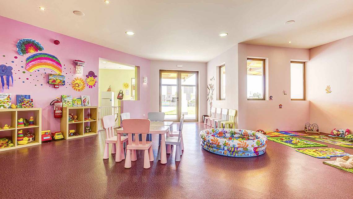 Kinderzimmer im Club Plimmiri Hotel mit bunten Wänden, Spielzeug und Spielbereich.