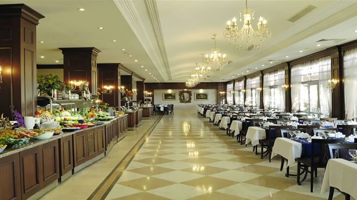 Innenansicht des Restaurants im Club Cactus Paradise Hotel mit gemustertem Boden, gedeckten Tischen und einer langen Salatbar.