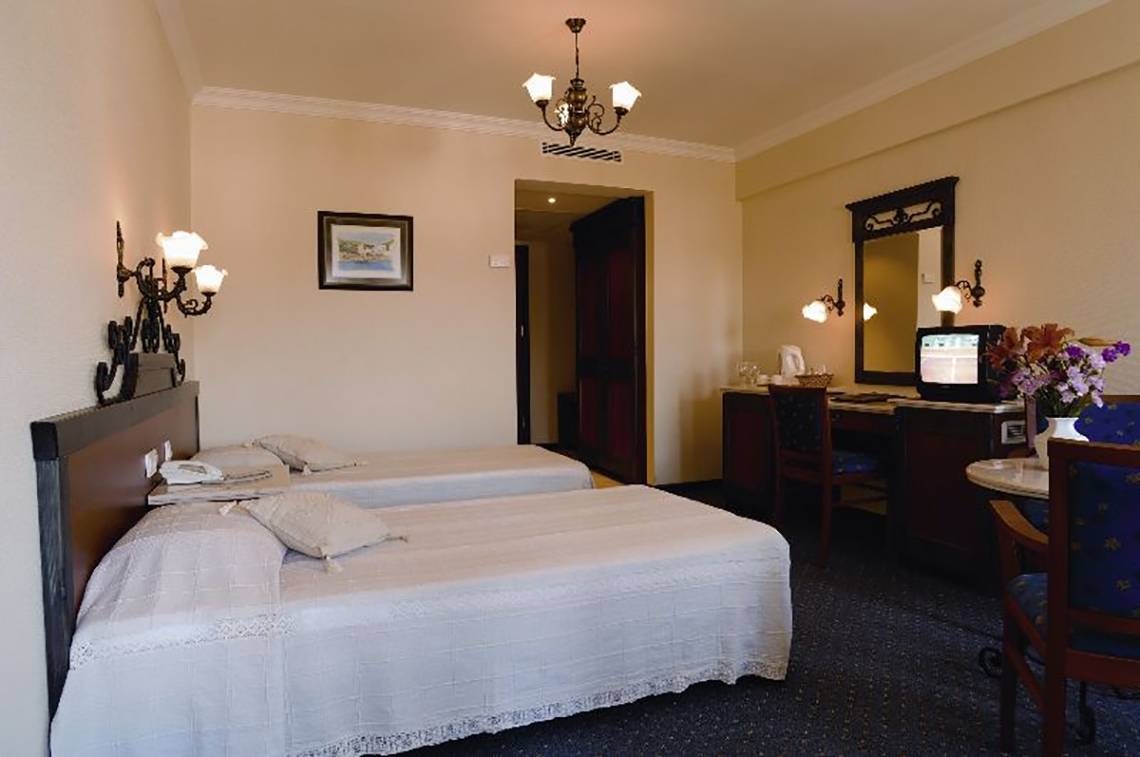 Doppelzimmer im Club Cactus Paradise Hotel mit zwei Betten, Schreibtisch und Fernseher.