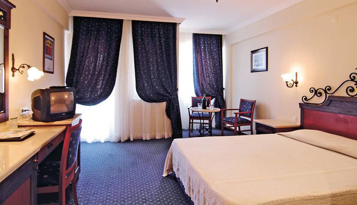 Hotelzimmer im Club Cactus Paradise mit Doppelbett, Fernseher und Schreibtisch.
