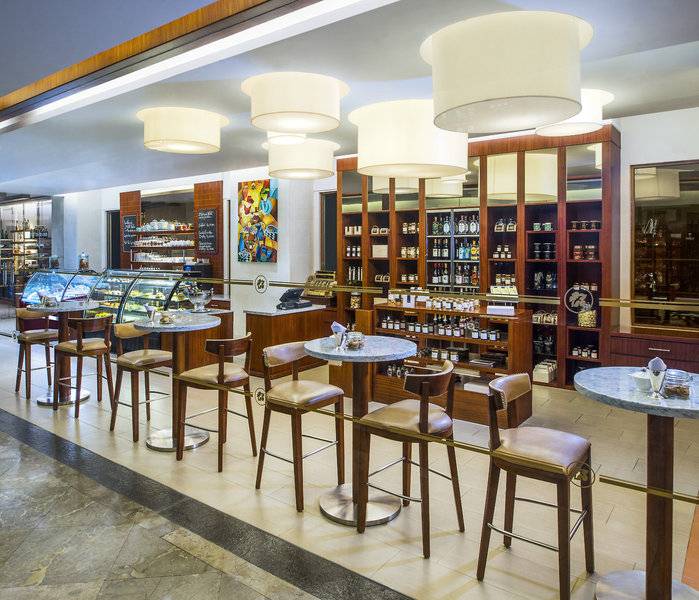 Inneneinrichtung des Laguna, einem Luxus-Collection-Resort & Spa mit Tischen, Stühlen und Regalen voller Flaschen.