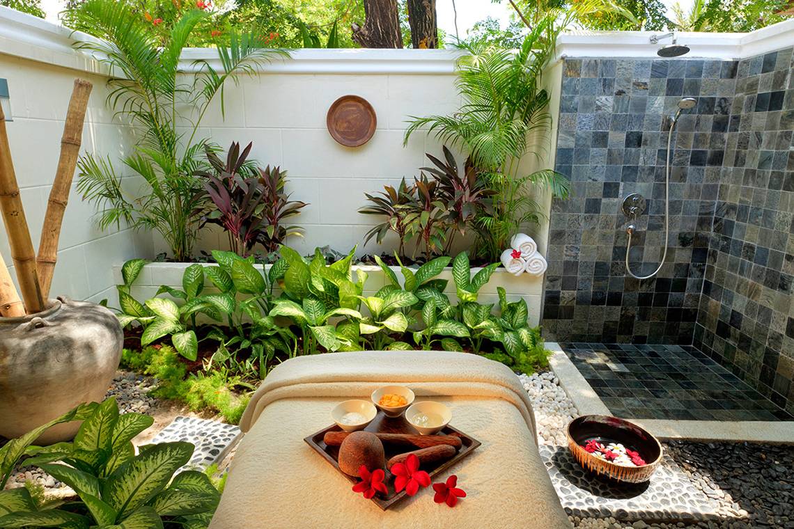 Außenbereich des Kurumba Maldives Hotels mit einer Spa-Behandlung und Pflanzen.