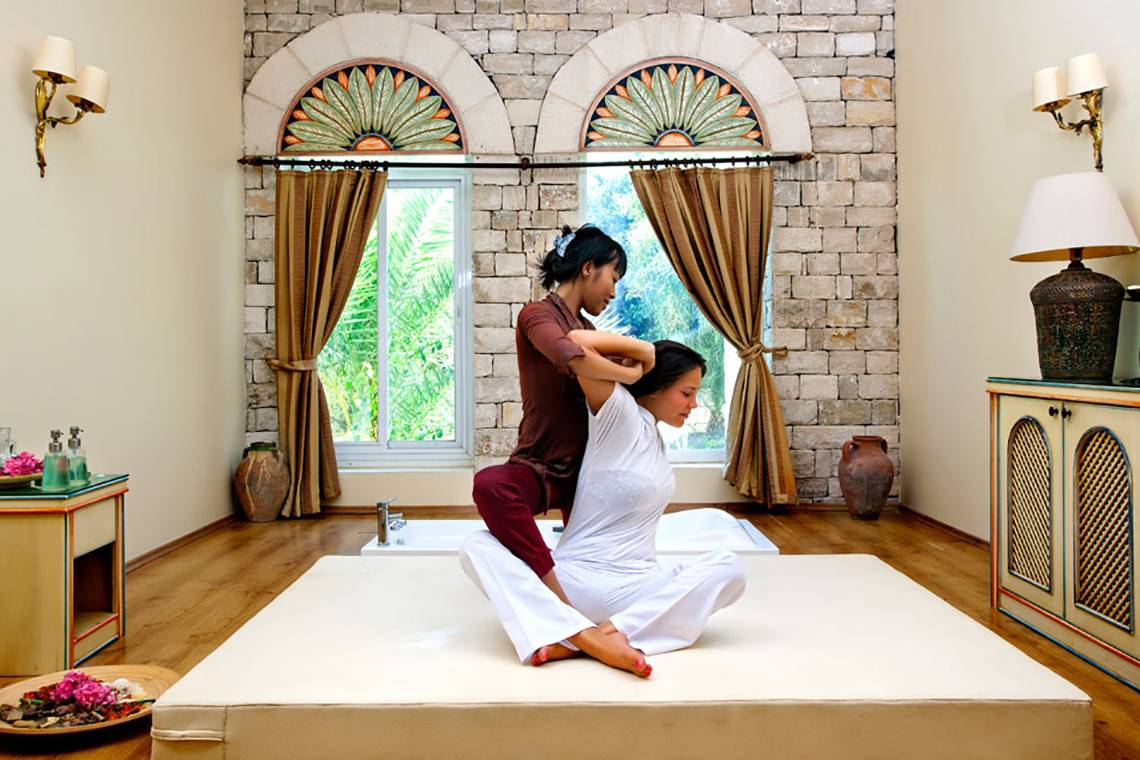 Massage im Salmakis Resort & Spa mit einer Frau auf einer weißen Matte.