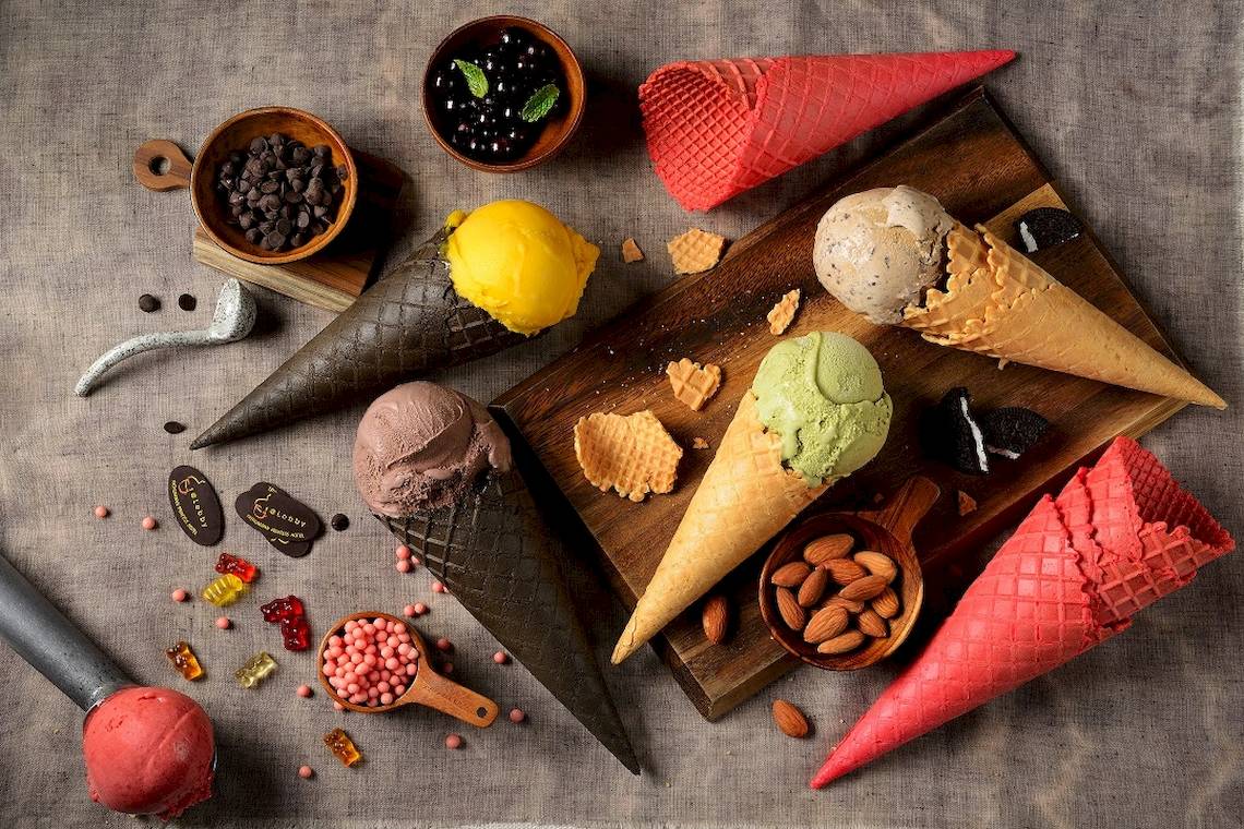 Eiswaffeln mit verschiedenen Eissorten und Toppings auf einem Holzbrett