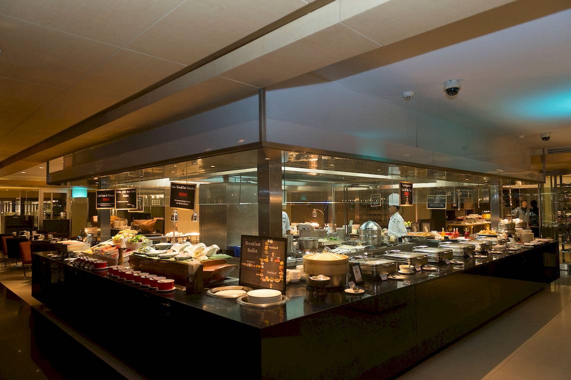 Frühstücksbuffet im Pathumwan Princess Hotel mit verschiedenen Speisen und Köchen im Hintergrund.