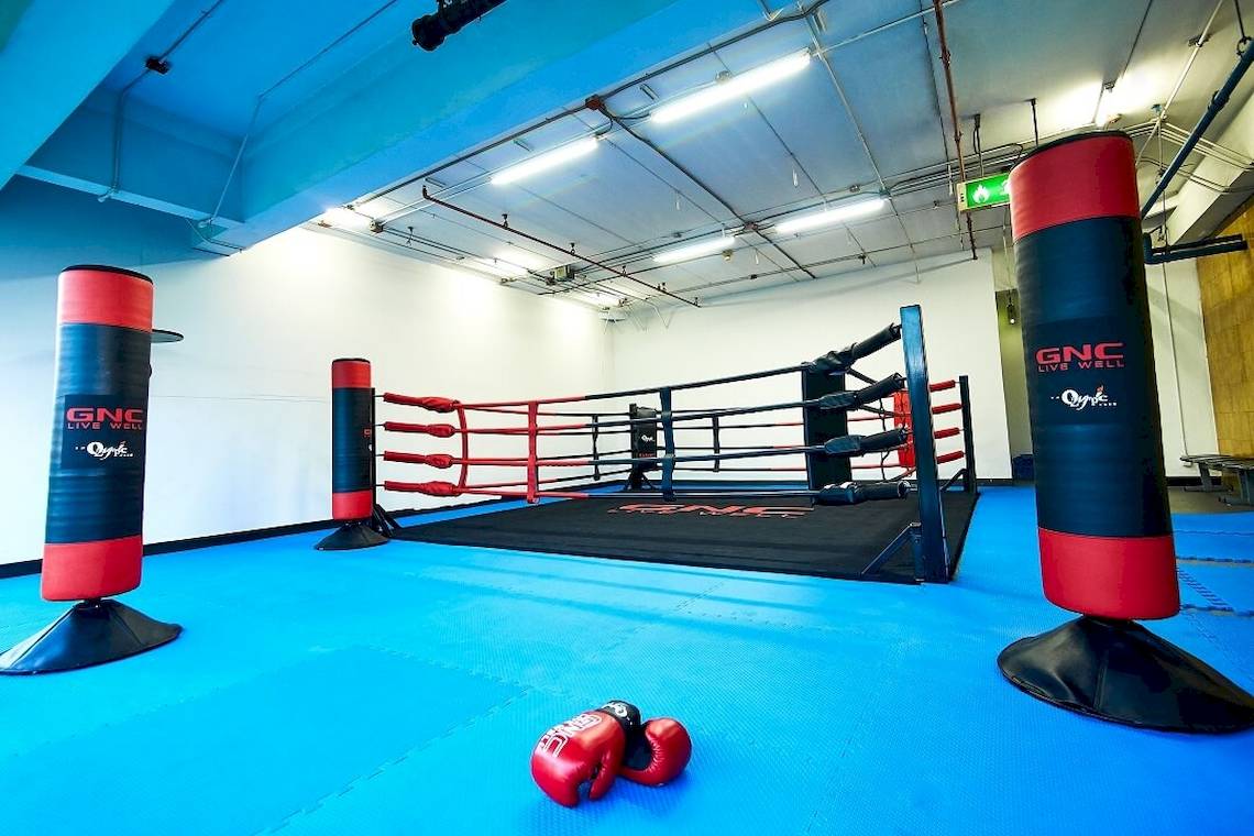 Box-Trainingsbereich im Pathumwan Princess Hotel mit roten Boxhandschuhen und roten Boxständern.