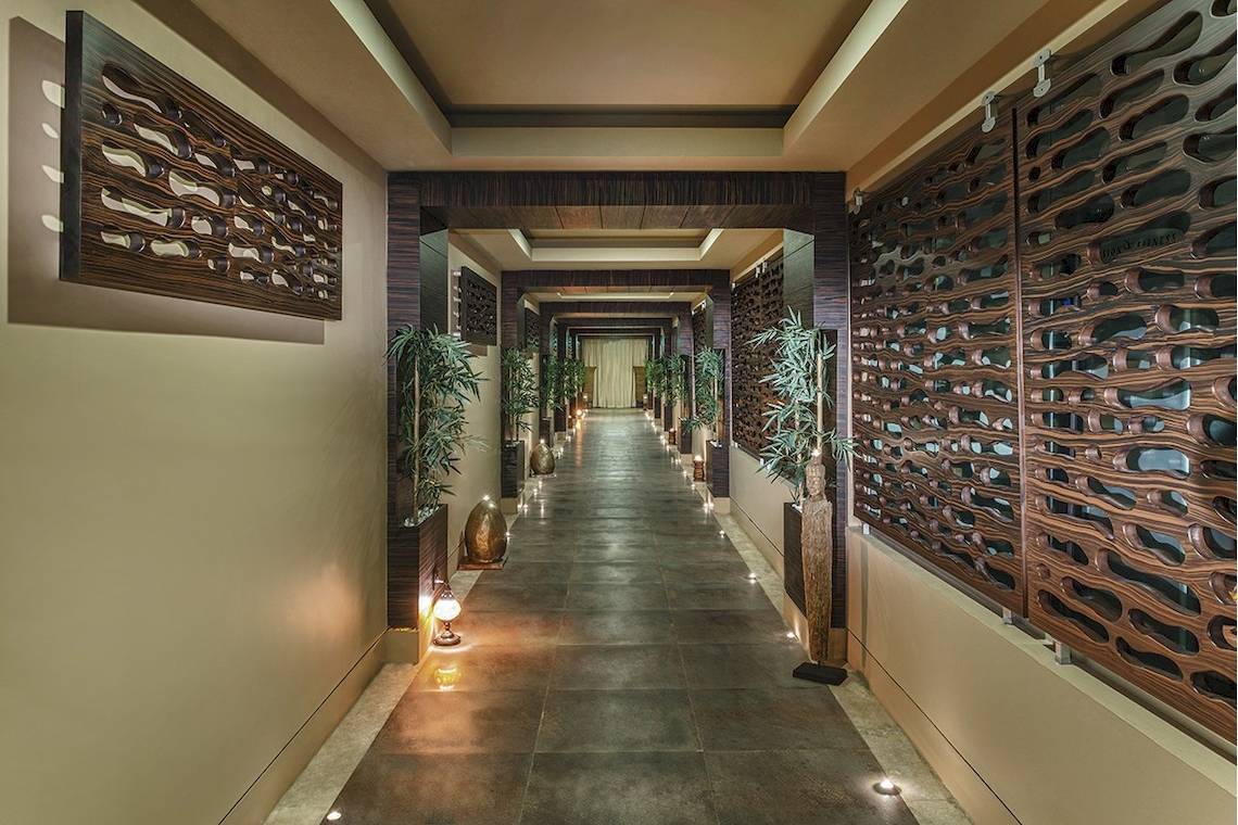 Korridor im Voyage Torba Hotel mit Holzwänden und Pflanzen.