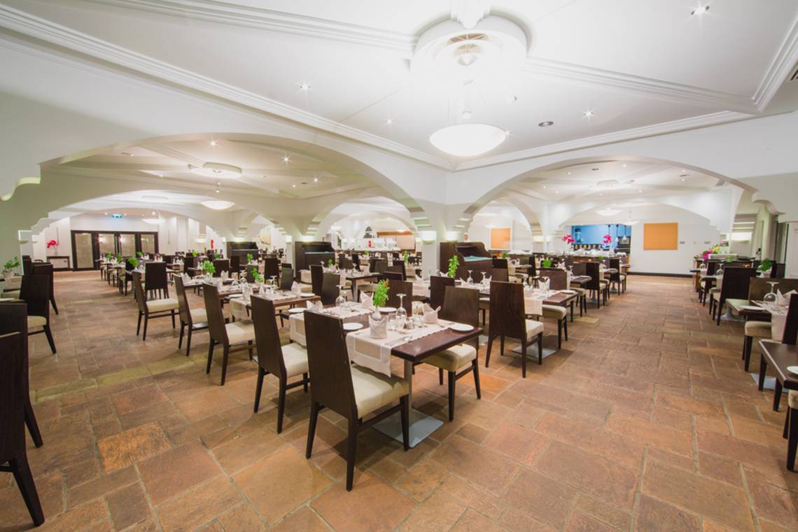 Innenbereich des Napa Plaza Hotels mit Restaurantbereich, gedeckten Tischen und hohen Decken.