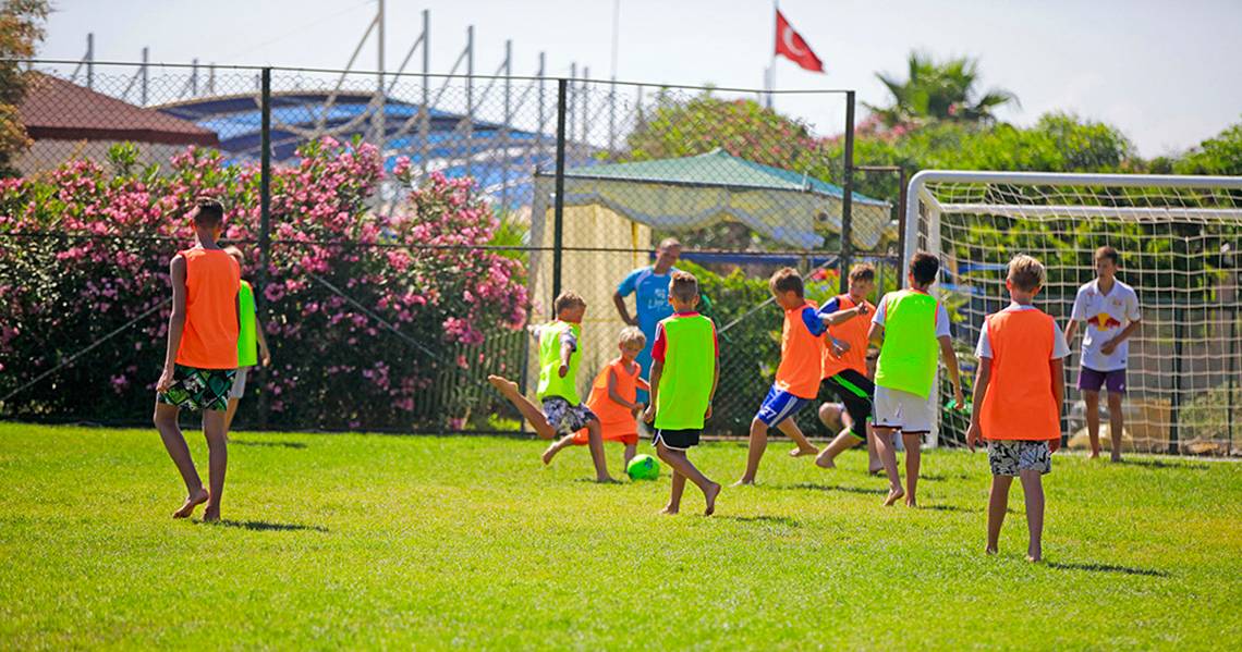 Kinder spielen Fußball auf einem Feld im Freien im Selectum Family Comfort Side Hotel.