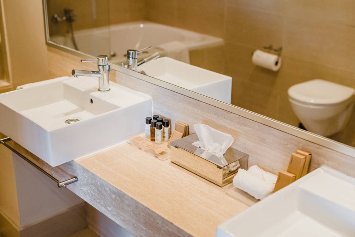 Badezimmer im Napa Plaza Hotel mit Waschbecken, Toilette und Spiegel