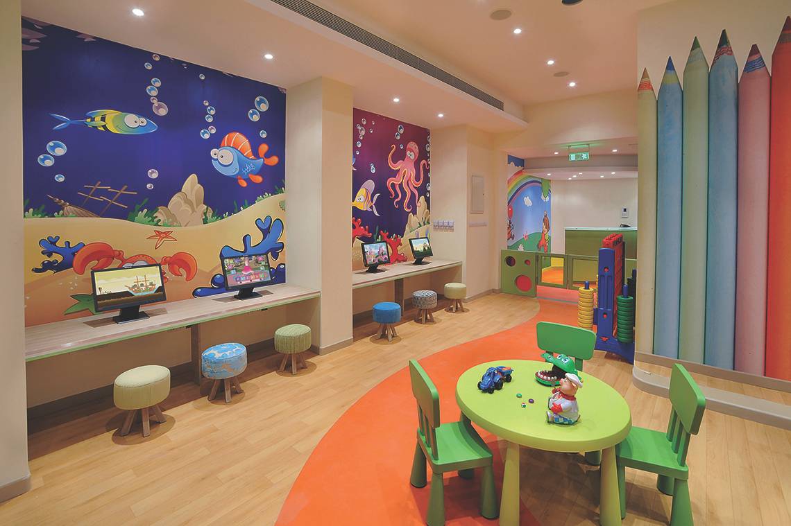 Kinderzimmer im Alexander The Great Hotel mit bunten Wandmalereien und Spielzeug.