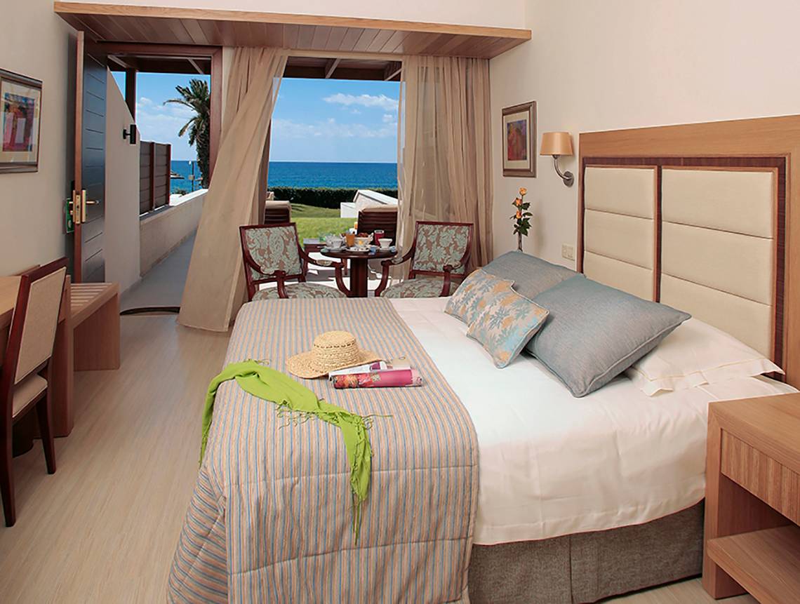 Zimmer im Alexander The Great Hotel mit Blick auf das Meer und eine Terrasse.