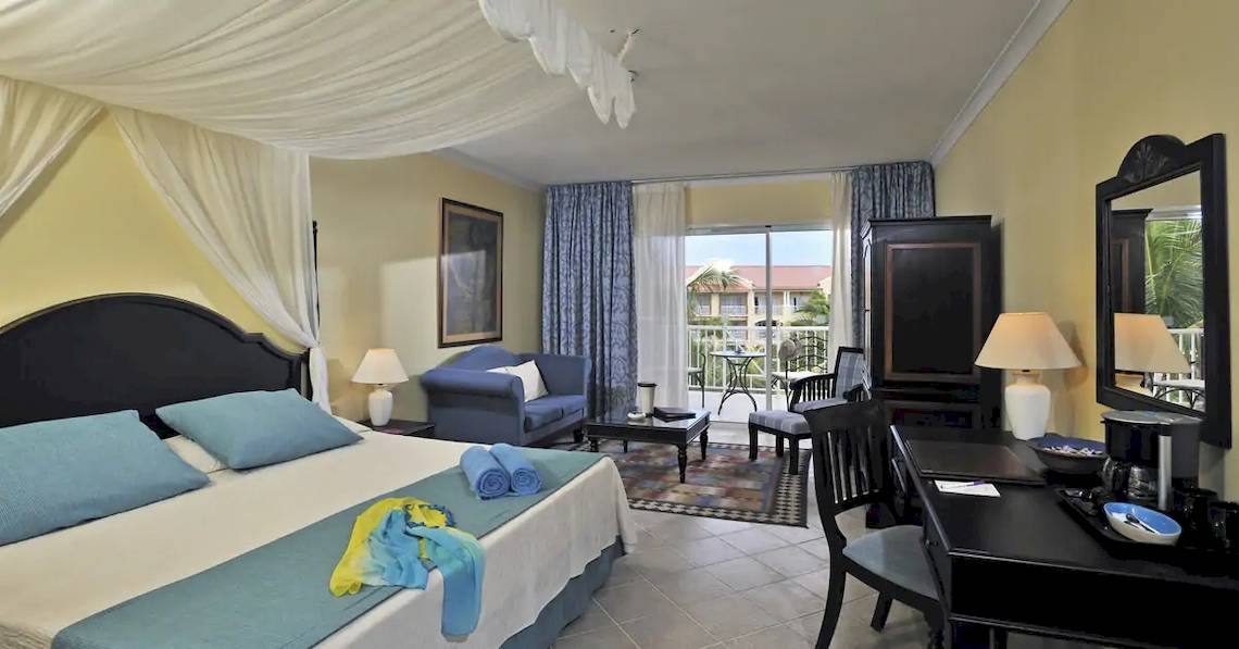 Hotelzimmer im Paradisus Princesa del Mar Resort & Spa mit Bett, Couch, Tisch, Lampen und Balkon
