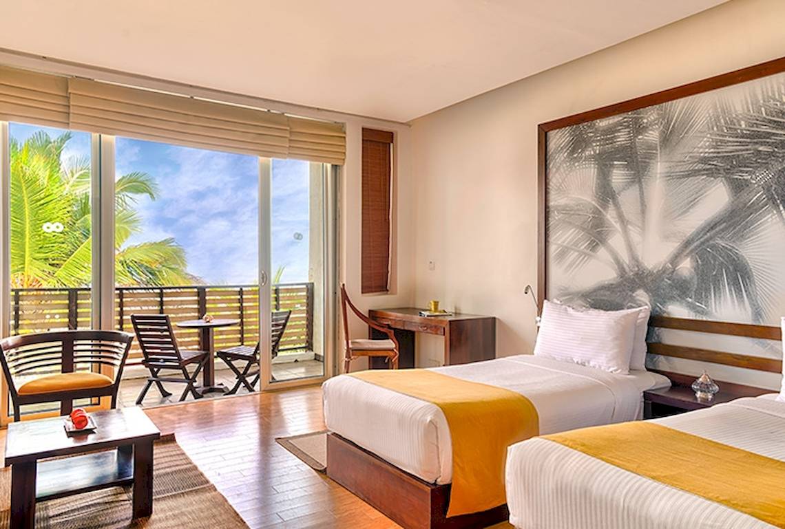 Zimmer im Jetwing Sea Hotel mit Blick auf den Balkon und das Meer.