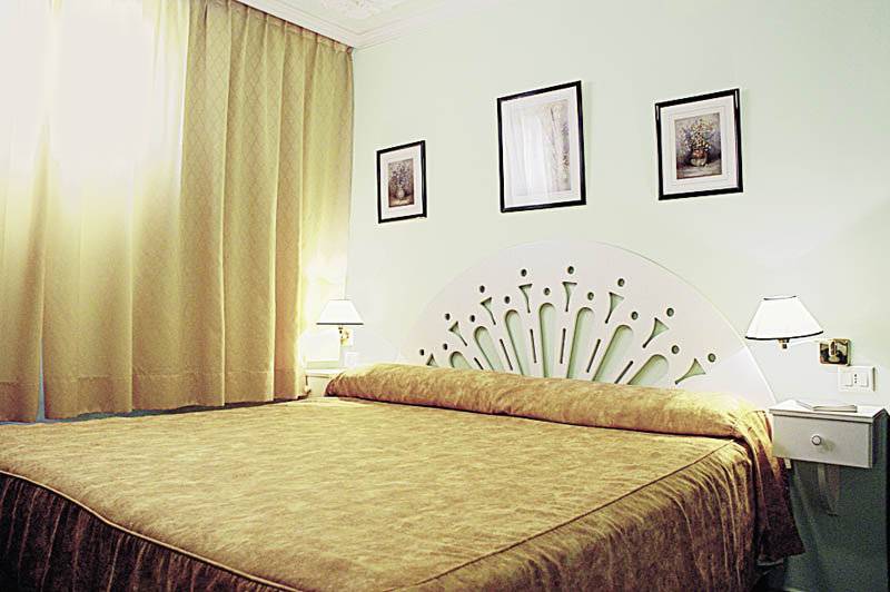 Doppelbett im Hotelzimmer des Rey Carlos mit drei Bildern an der Wand