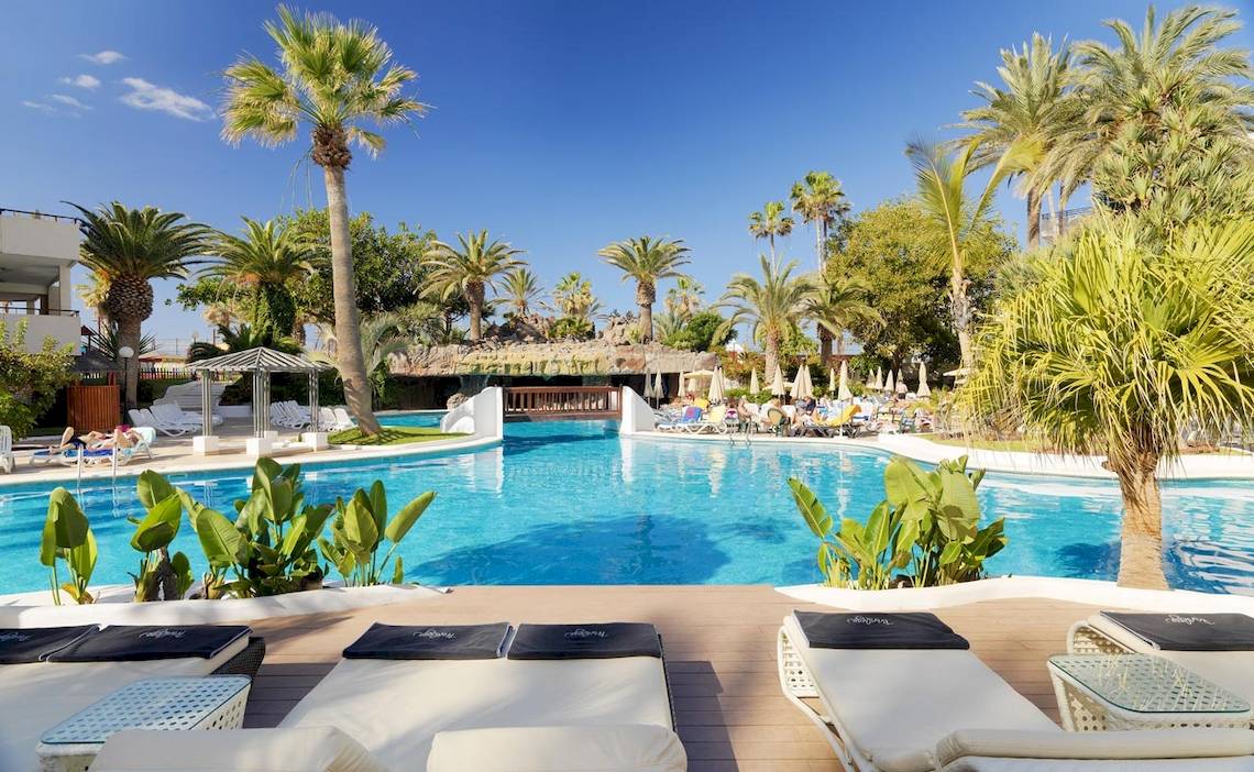 Außenpool und Loungebereich des H10 Conquistador Hotels mit weißen Sonnenliegen und blauem Wasser