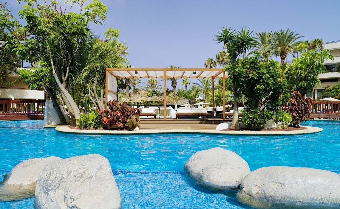 Pool des H10 Conquistador Hotels mit einer Gazebo und Palmen