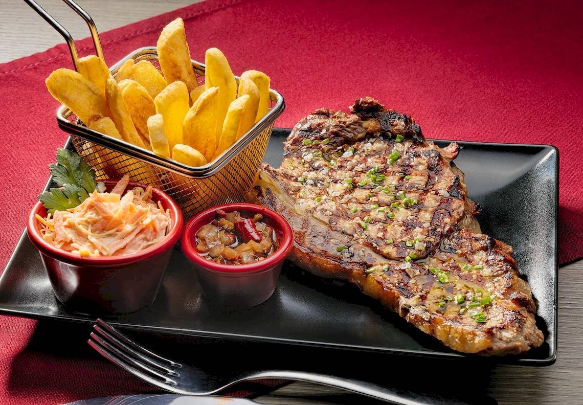 Teller mit Steak, Kartoffeln und Saucen im H10 Conquistador