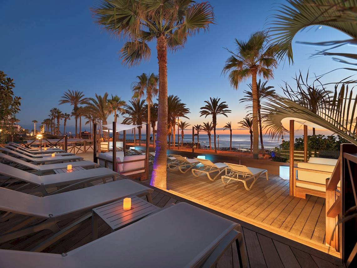 Abendliche Terrasse des H10 Conquistador Hotels mit Blick auf den Ozean und Palmen