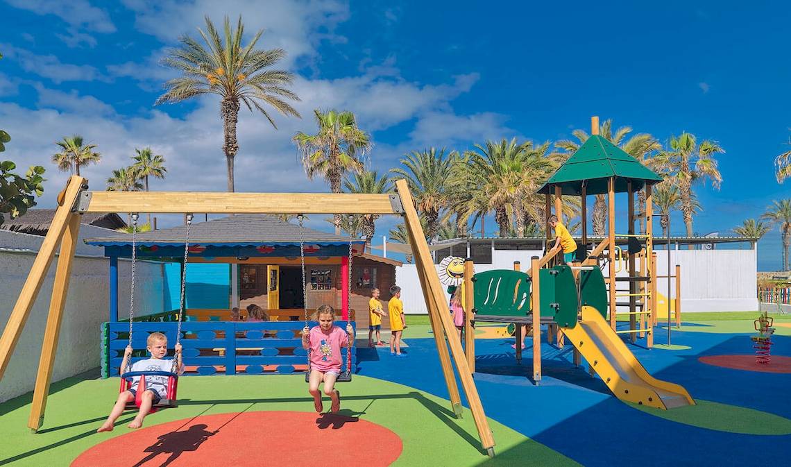 Kinderspielplatz im Freien im H10 Conquistador Hotel mit Schaukeln, Rutsche und Spielgeräten